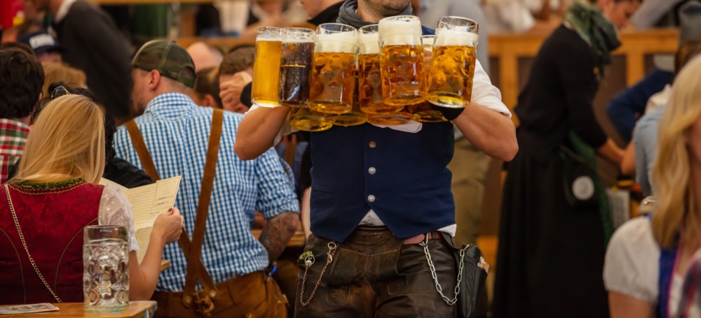 Oktoberfest, München, Duitsland. Ober met traditionele klederdracht die bieren serveert, close-up view