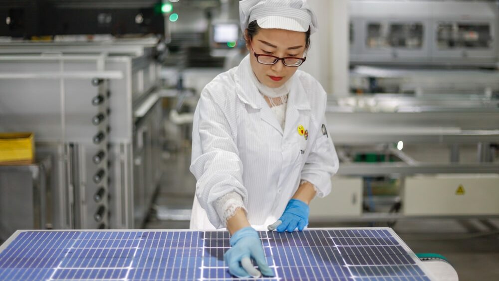Arbeiders bedienen apparatuur om fotovoltaïsche printplaten te produceren in een productiewerkplaats van een groene energietechnologiebedrijf in Jiujiang, provincie Jiangxi.