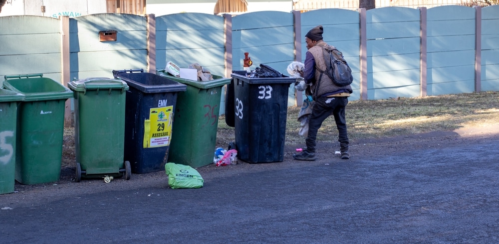 Johannesburg, South Africa - unidentified black man collects single-use plastic from household dustbins
