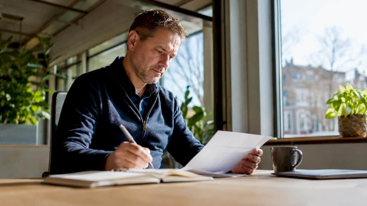 Man die op kantoor de risicoregisters doorneemt